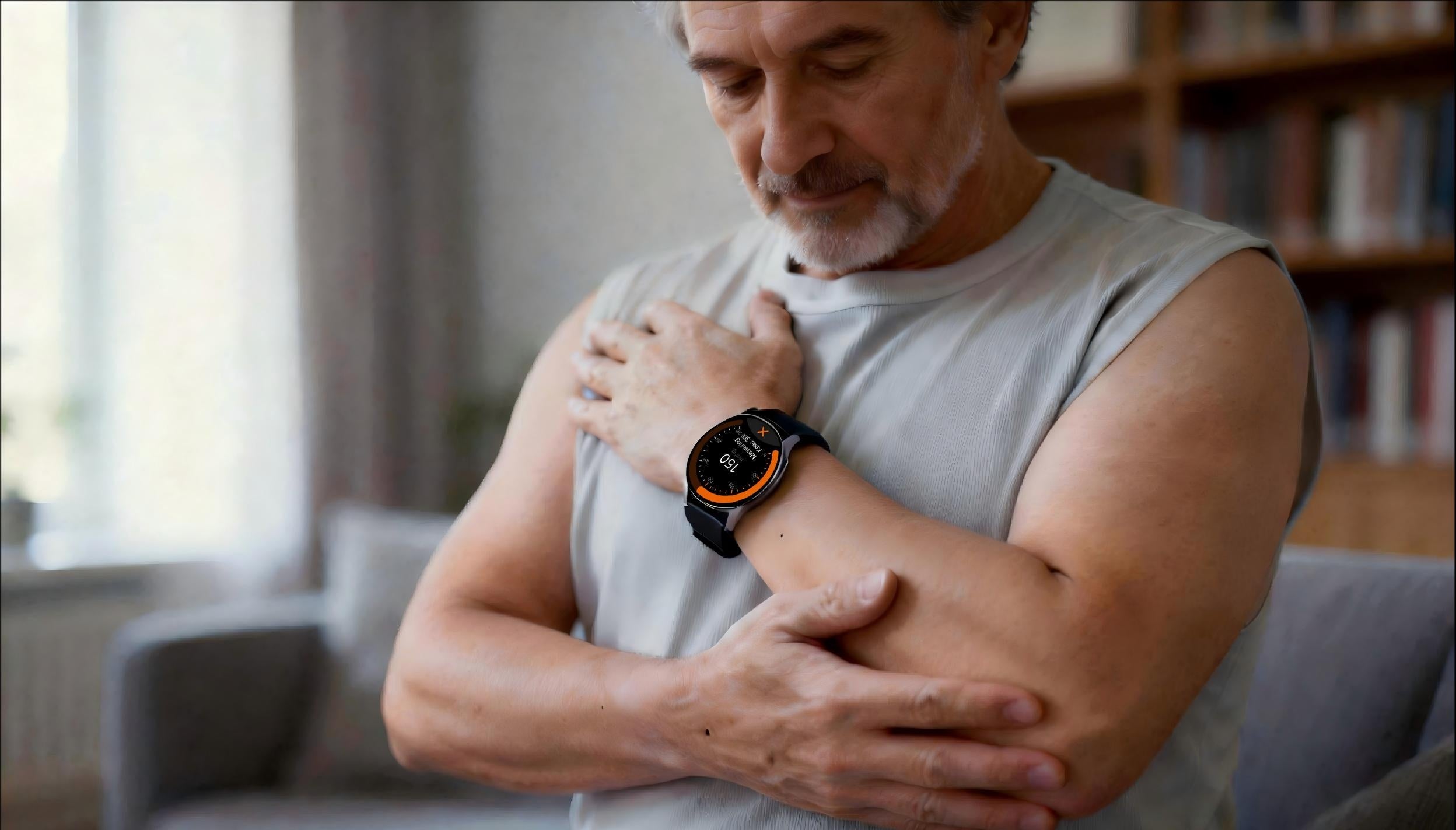 An older man holds his wrist up at chest height while his watch takes a blood pressure reading